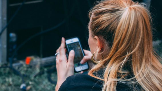 Eine Frau tippt auf ihrem Handy.