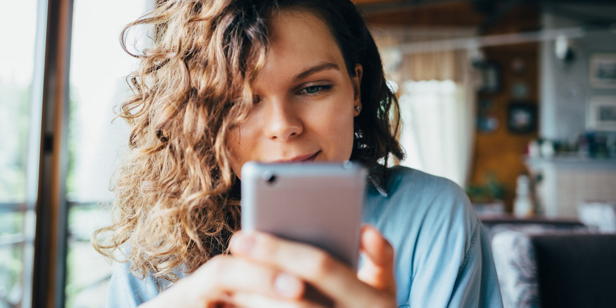 Eine Frau scrollt durch Social-Media-Feeds.